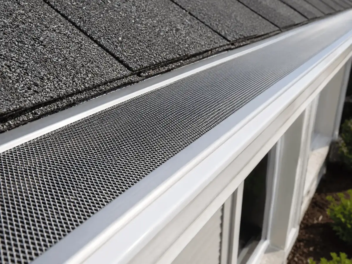 Close view of gutter guard mesh over an aluminum gutter