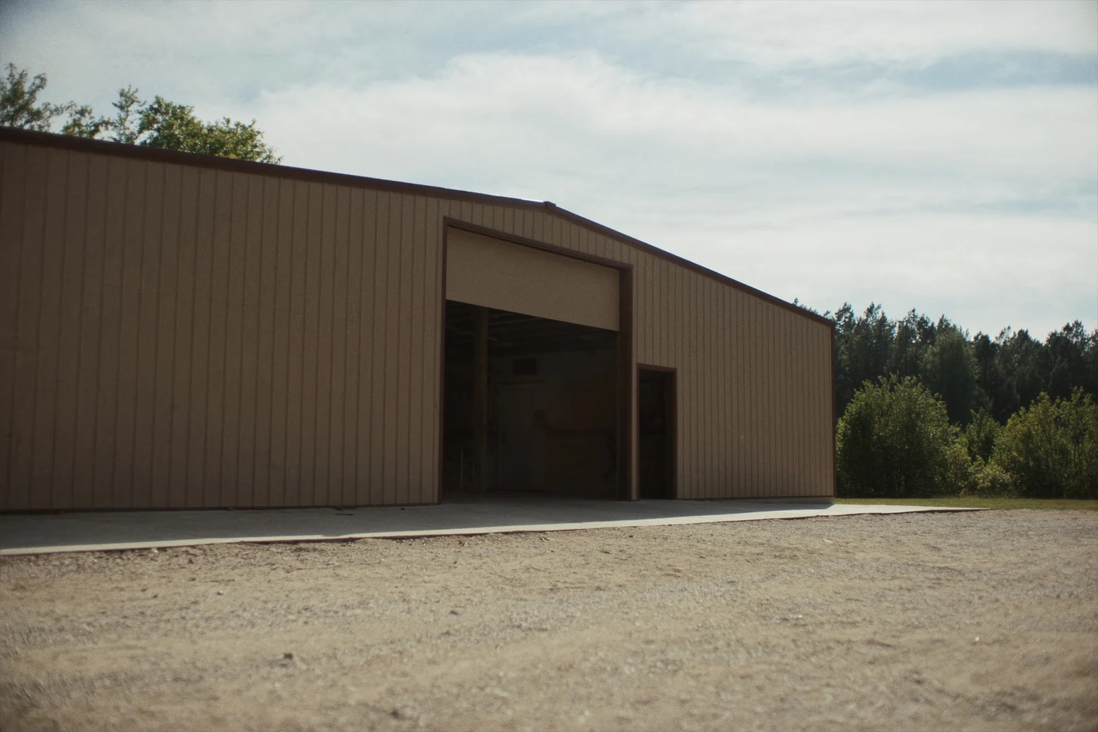 Large metal building with a big overhead door and a walk-in door