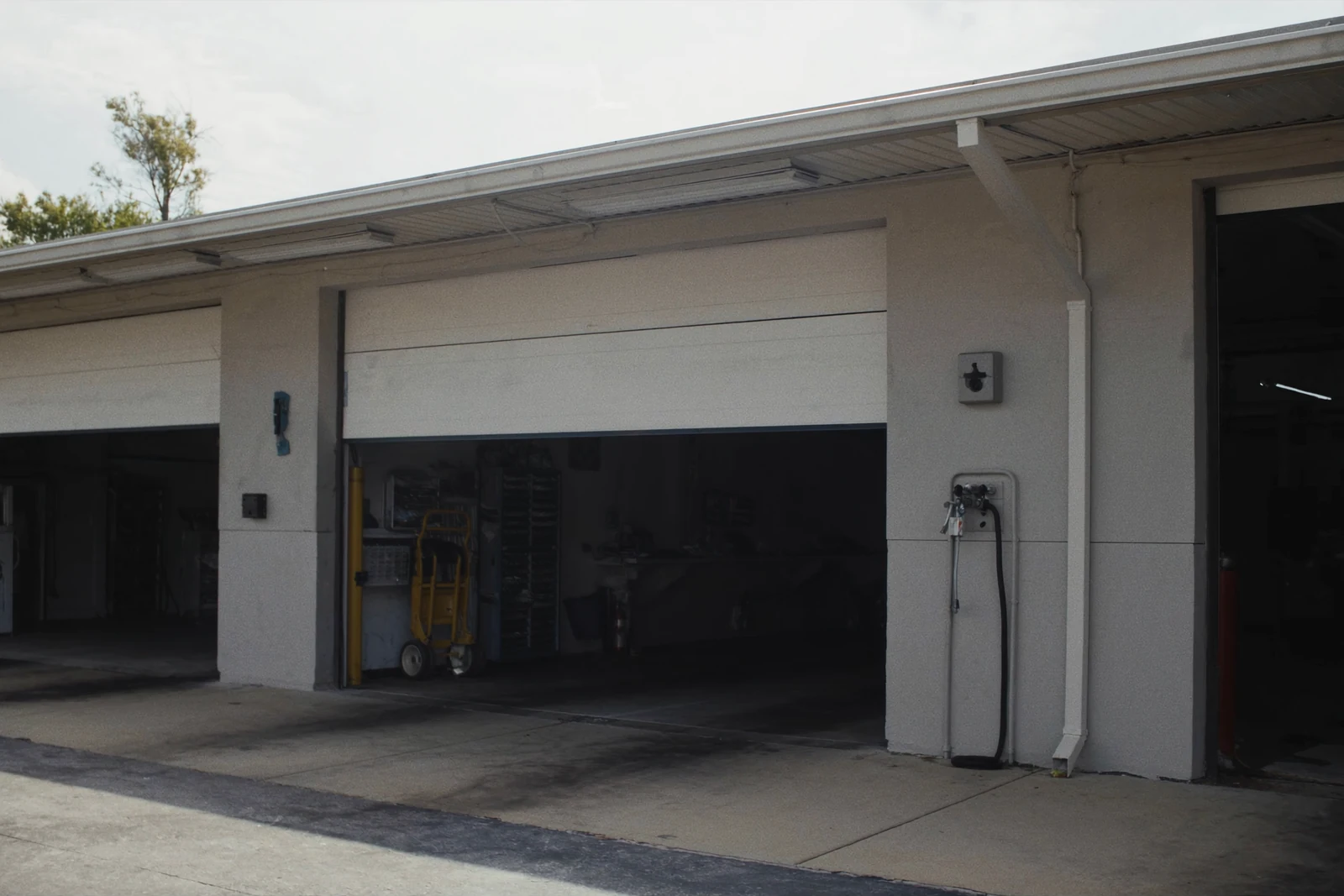 Service building with a white overhead bay door raised open
