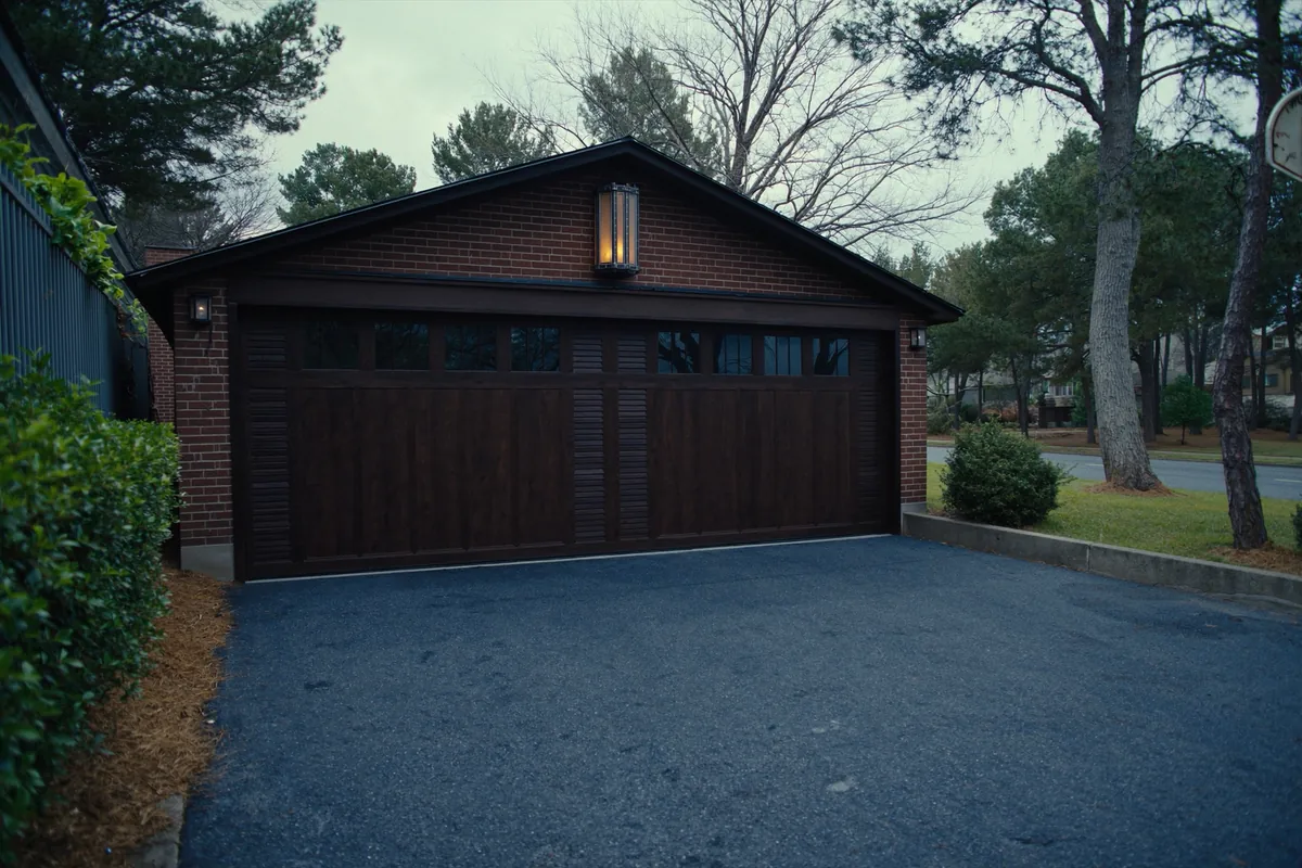 Dark brown carriage-style garage door on a brick two-car garage