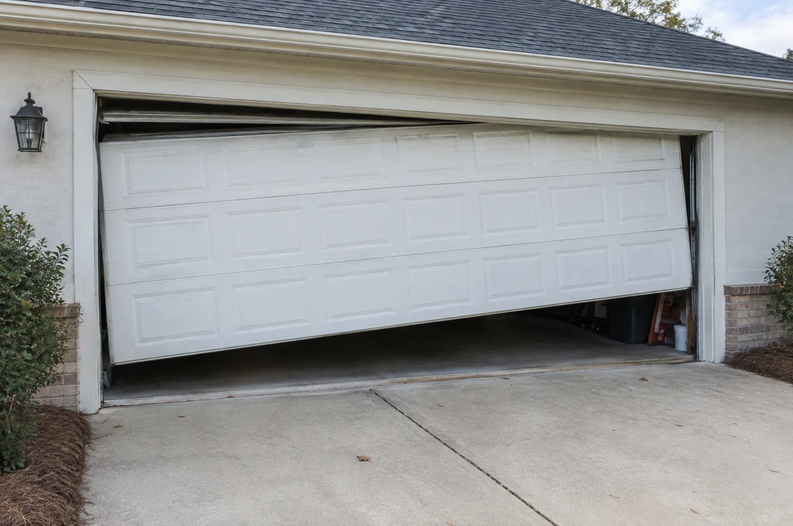 Garage door stuck partly open and hanging crooked