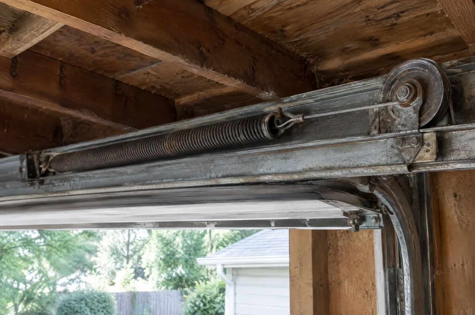 Extension spring and pulley along the side track of a garage door