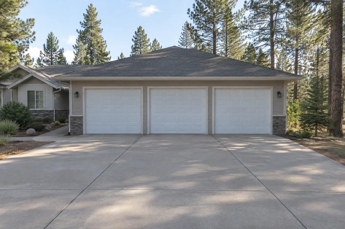 Single-story home with three white garage doors side by side