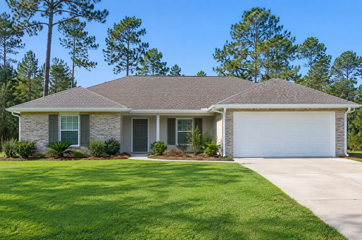 Single-story home with white gutters along the roofline and a white garage door