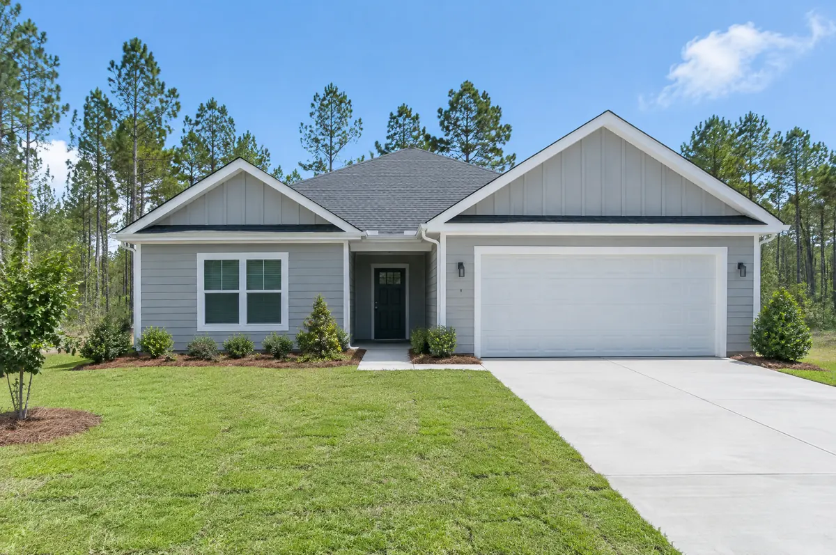 Newly built single-story home with fresh sod and a new driveway
