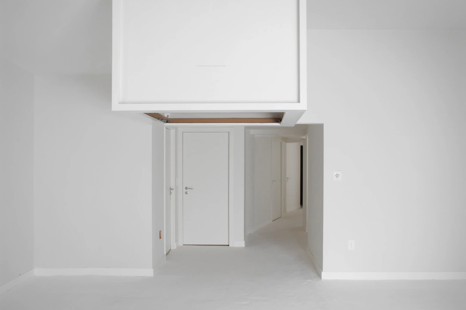 Hallway of a new house with an attic access hatch in the ceiling