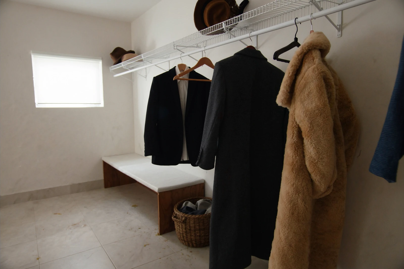 Entry closet with a wire shelf above a rod holding coats