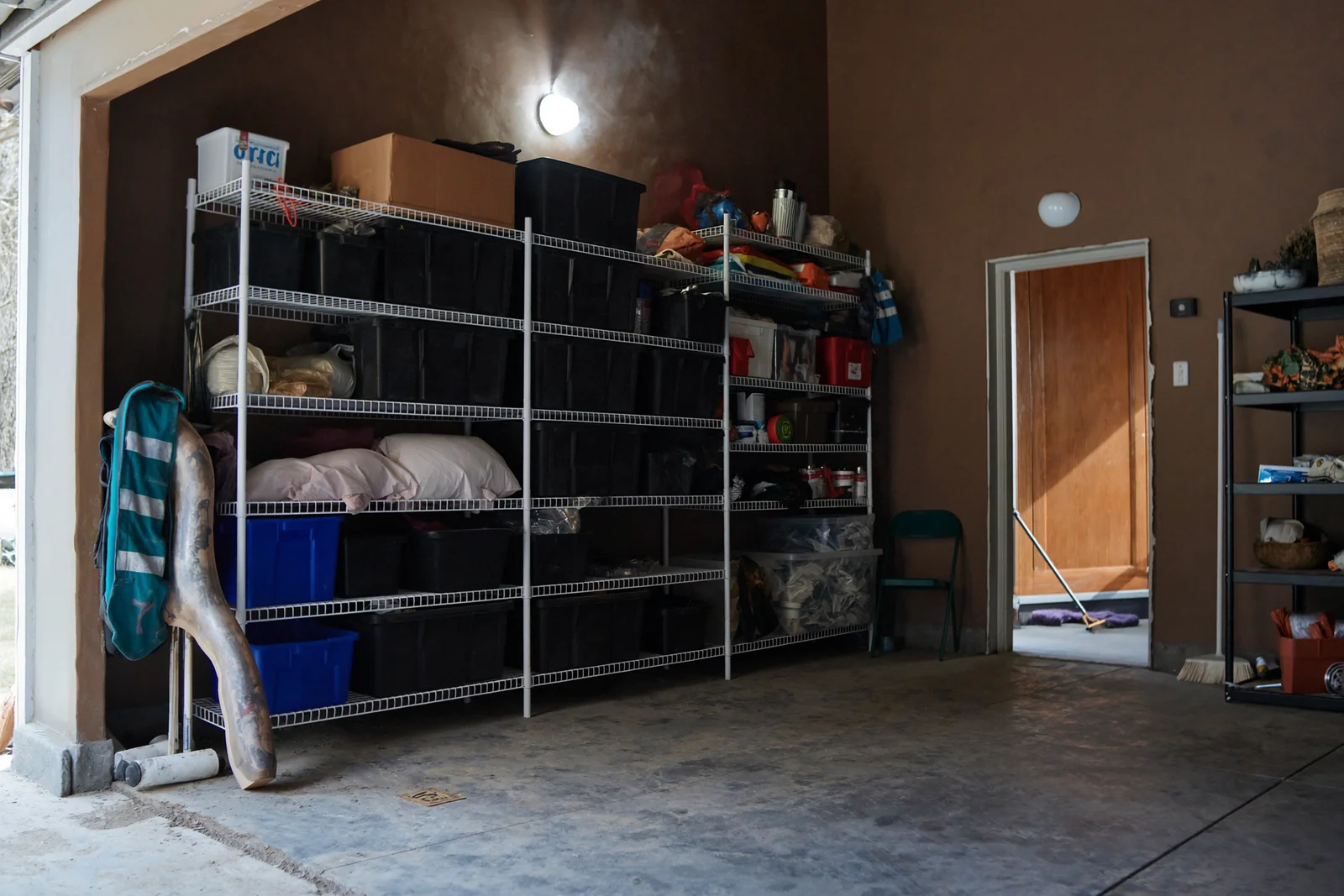 Garage wall with heavy-duty wire shelving holding storage bins
